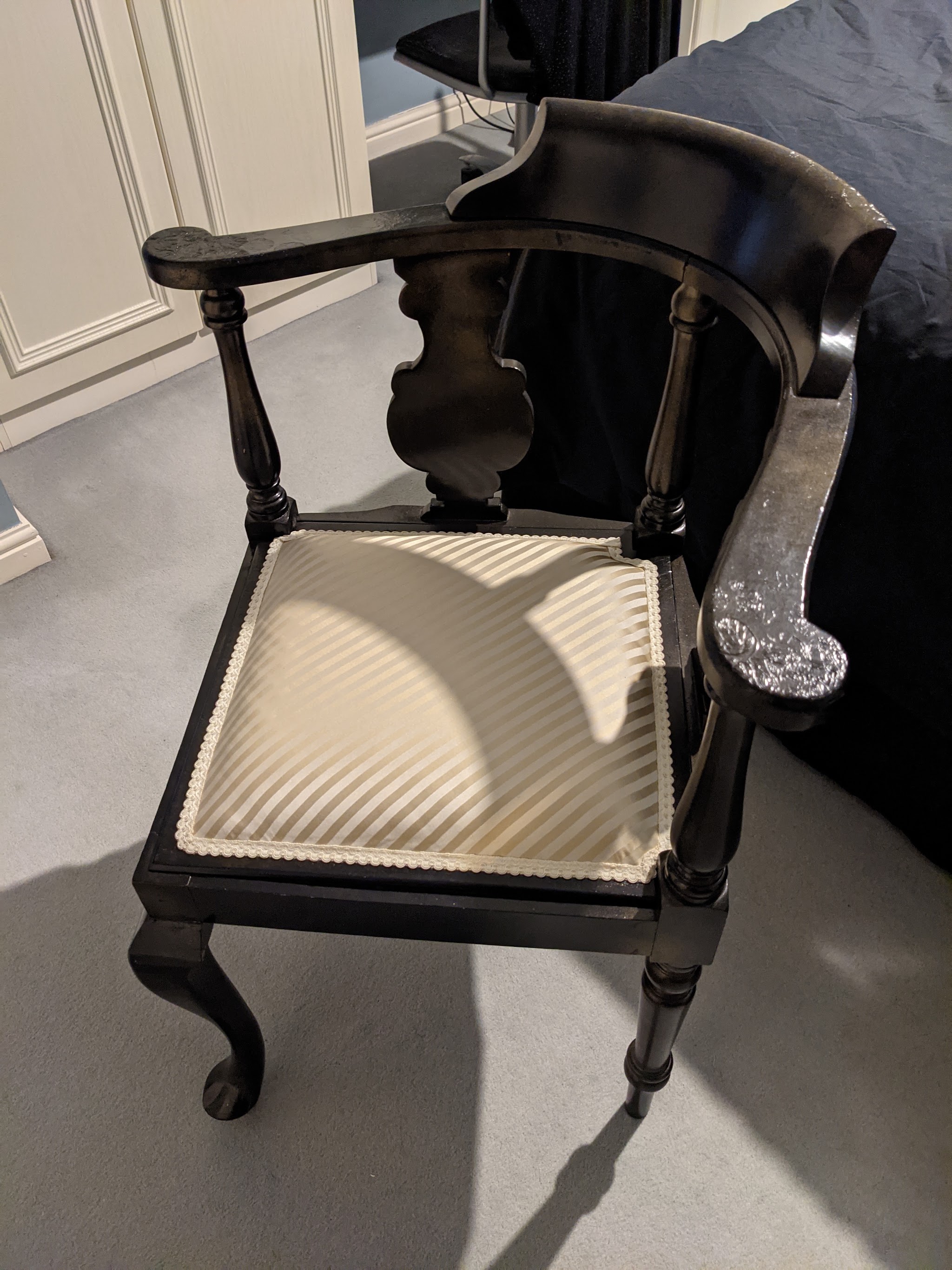An ebonised corner chair with a new striped seat in a customer's home