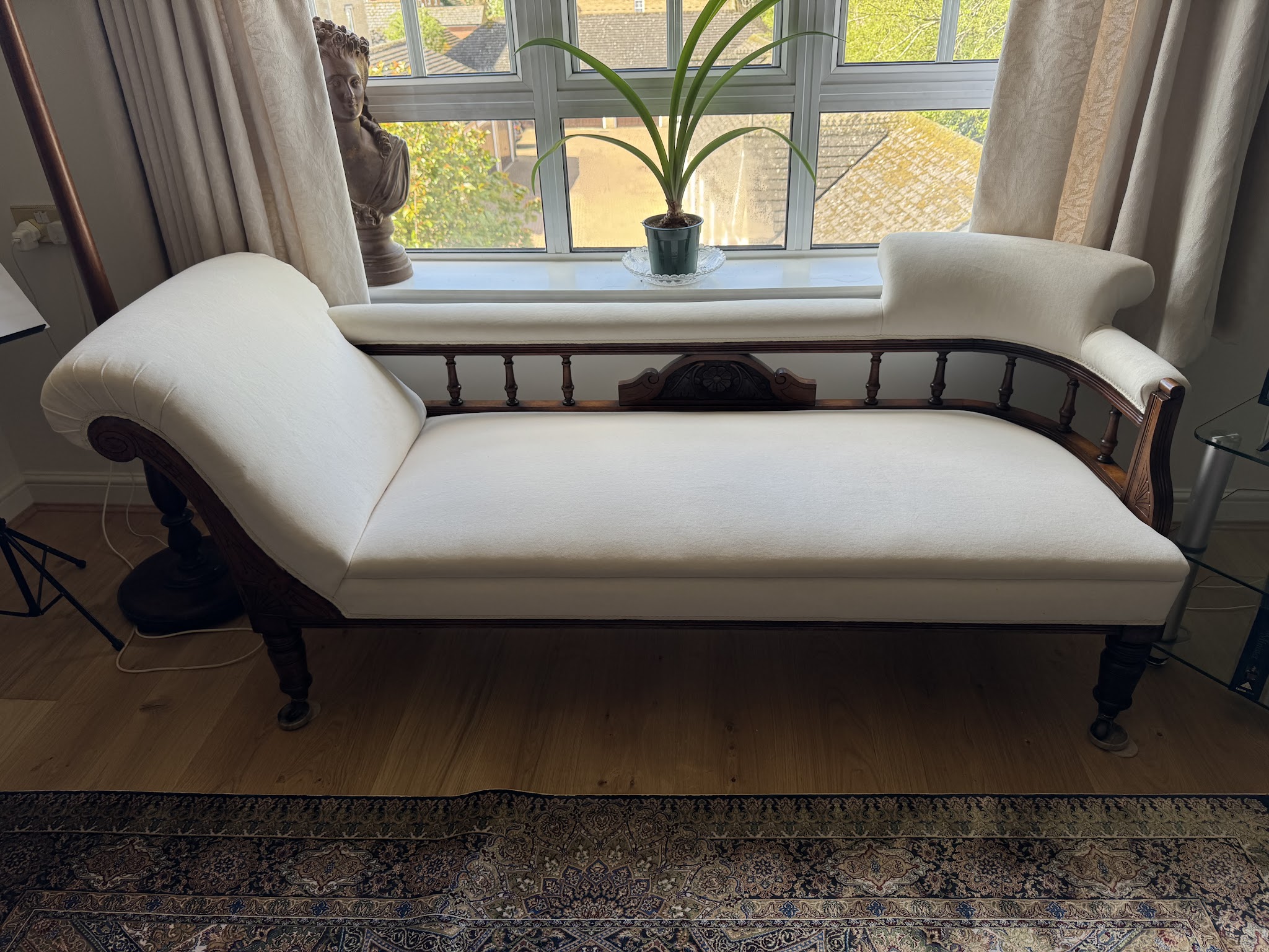 A spindle-back chaise longue in ivory fabric