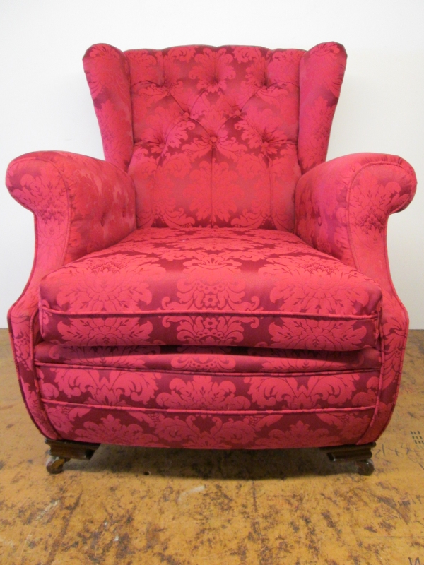 A wing armchair re-upholstered in red damask