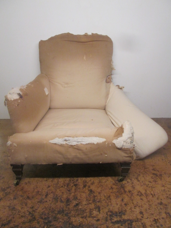 A Victorian armchair with its covers stripped
