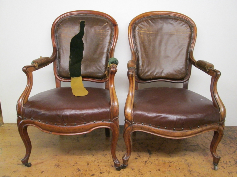 A pair of French armchairs part way through re-upholstery