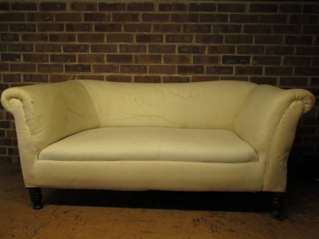 A two-seater sofa re-upholstered in pale fabric